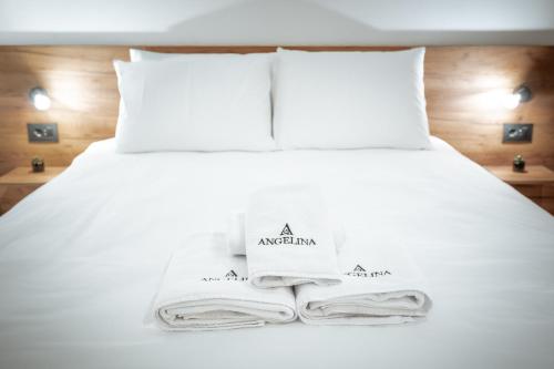a white bed with towels and pillows on it at Angelina Apart Hotel&Spa in Divčibare