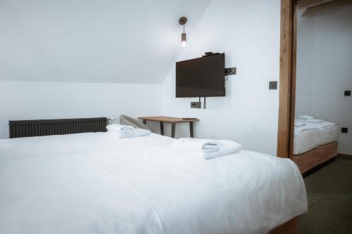 a bedroom with a white bed and a flat screen tv at Angelina Apart Hotel&Spa in Divčibare