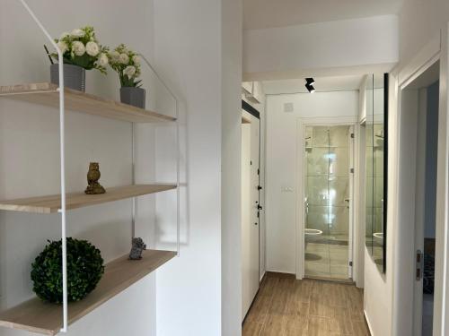 a hallway with white walls and wooden shelves at LiboroApartments in Niš
