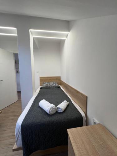 a bedroom with a bed with two towels on it at LiboroApartments in Niš