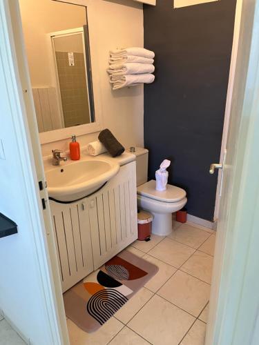 a bathroom with a sink and a toilet at Le 63* in La Trinité
