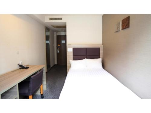 川口市にあるSmile Hotel Kawaguchi - Vacation STAY 05008vのベッドと机があるホテルの部屋