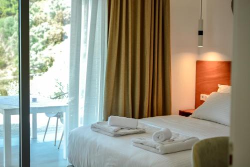 una camera d'albergo con un letto con asciugamani sopra di Elysium Luxury Living Skiathos a Città di Skiathos