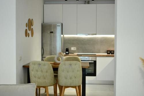 una cucina con un tavolo di legno e due sedie di Elysium Luxury Living Skiathos a Città di Skiathos