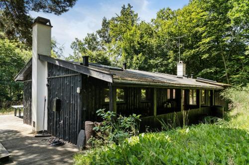 an old black and white building with trees in the background at Architect Designed With Two Wings By Tisvilde Hegn in Tisvildeleje