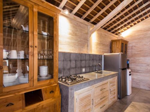 a kitchen with a stove and a refrigerator at Villa du Bah in Kerobokan