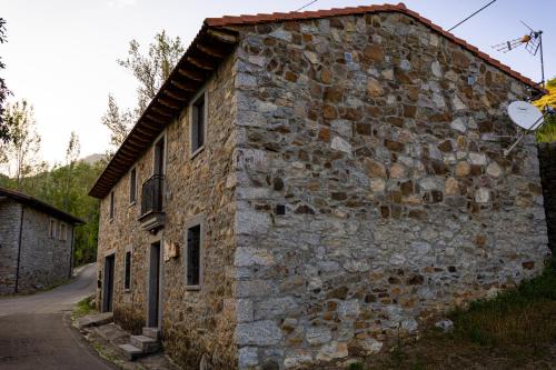 an old stone building on the side of a road at Casa Rural Sensaciones 3 dormitorios con jardin in Carrocera