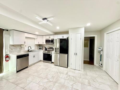 eine große Küche mit weißen Schränken und Geräten in der Unterkunft Historic Barn View Modern Country Newton House in Newton