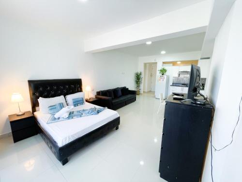 une chambre avec un lit et une télévision dans l'établissement LOS CORALES del Mar STUDIOS & SUITES SPA, à Punta Cana