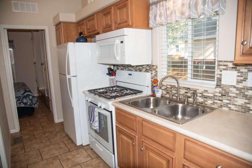 una cocina con fregadero y estufa horno superior en Pack Creek Cabin #23, en Moab