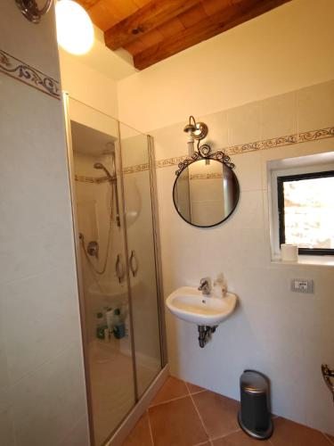a bathroom with a shower and a sink and a mirror at The house in the paradise of Serra. in Chiusi della Verna