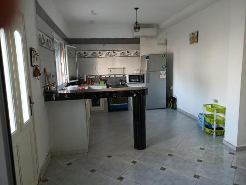 a kitchen with a counter and a refrigerator at La maison des senteurs in El Kala