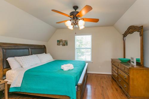 a bedroom with a bed with a ceiling fan and a dresser at Huge Home For Groups Near Downtown in Nashville