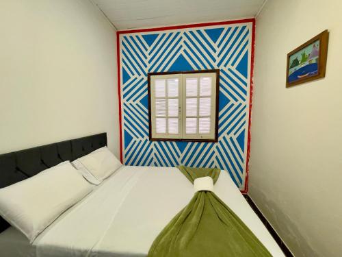 a small bedroom with a bed and a window at Hospedaria São Jorge in Sao Jorge