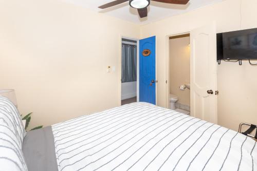 a bedroom with a bed and a flat screen tv at West End Inn Beachfront Hotel Room in West End in Roatan