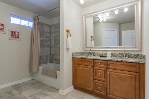 a bathroom with a sink and a tub and a mirror at Huge Home For Groups Near Downtown in Nashville