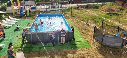 a group of people playing in a swimming pool at Pensiunea Ela Novaci in Novaci