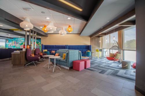 a lobby with colorful chairs and tables and windows at Tru by Hilton in McKinney