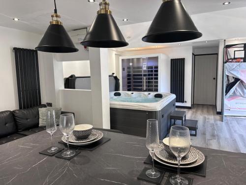 a room with a tub and a table with wine glasses at The Sauna House in Stockbury
