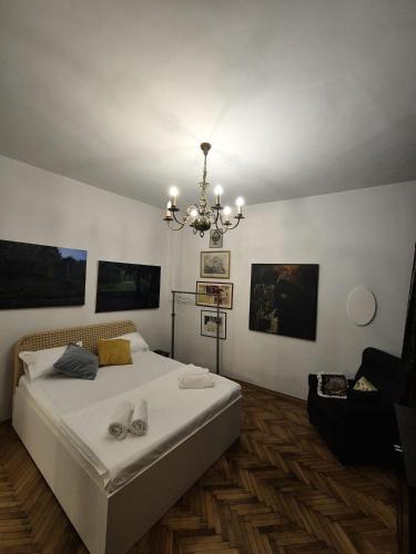 a bedroom with a large bed and a chandelier at Art Villa Bucharest in Bucharest
