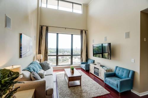 a living room with a couch and a tv at Luxury Uptown Penthouse in Charlotte