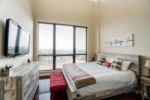 a bedroom with a large bed and a large window at Luxury Uptown Penthouse in Charlotte