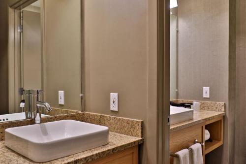 un bagno con un lavandino e un grande specchio di Killington Grand Resort Hotel a Killington