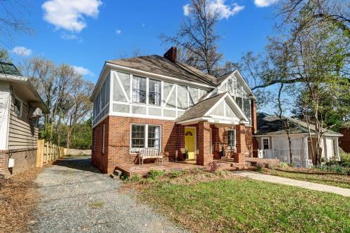 a red brick house with a yellow door at Dilworth Dream Cottage in Charlotte