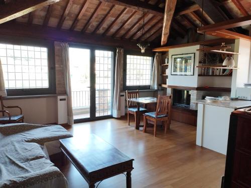 eine Küche und ein Wohnzimmer mit Tisch und Stühlen in der Unterkunft Attico in Villa Dona in Sacrofano