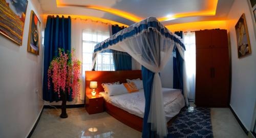 a bedroom with a bed with a blue canopy at Cozy 3BR Stay & Free Parking in Dodoma