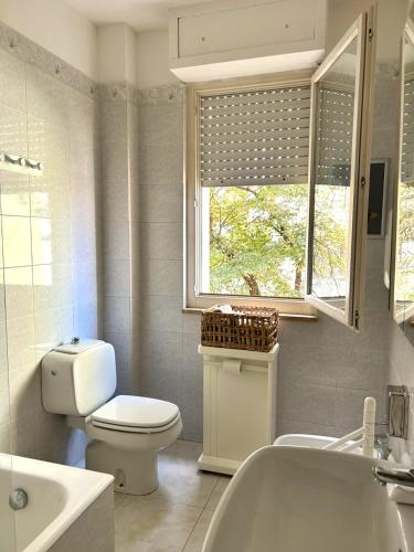 a bathroom with a toilet and a tub and a window at Affittacamere CUNCORDU Sassari in Sassari
