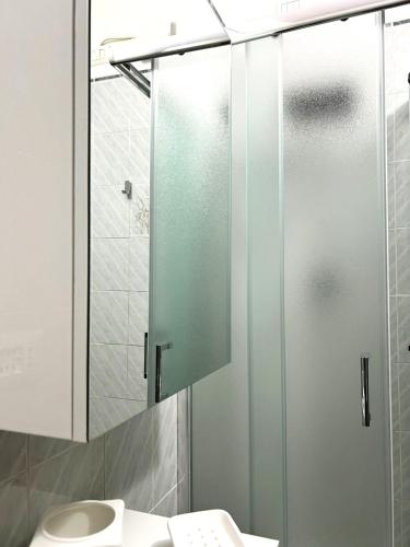 a bathroom with a glass shower door next to a toilet at Affittacamere CUNCORDU Sassari in Sassari