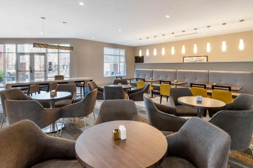 una sala de espera con mesas y sillas en DoubleTree by Hilton Summerville Nexton, en Summerville
