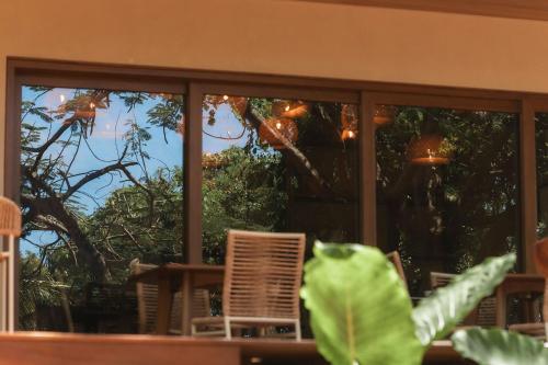 a room with a window with a chair and trees at Pousada Casa Mandacaru Noronha in Fernando de Noronha