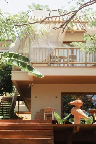 a toy duck sitting on top of a wooden railing at Pousada Casa Mandacaru Noronha in Fernando de Noronha