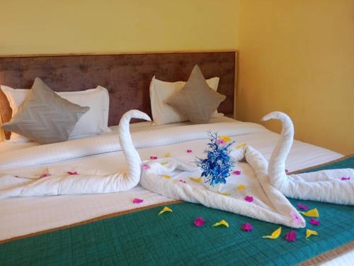two swans laying on a bed with flowers on it at Yuvraj Fort Pushkar by Data Mansa Hukam Pvt Ltd in Pushkar