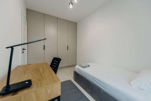 a bedroom with a desk and a bed and a desk at Apartamenty Jasionka Lotnisko in Rudna Mała