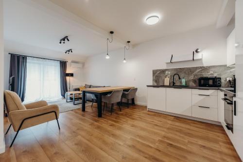 a kitchen and dining room with a table and chairs at Apartamenty Jasionka Lotnisko in Rudna Mała