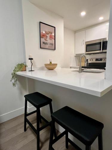 a kitchen with a counter and two black stools at Highview Studio in Vancouver