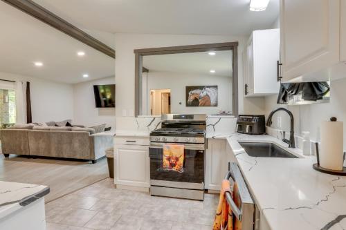 a kitchen with a stove top oven next to a couch at Riverfront Home with Porches and Views in Cotter! in Cotter
