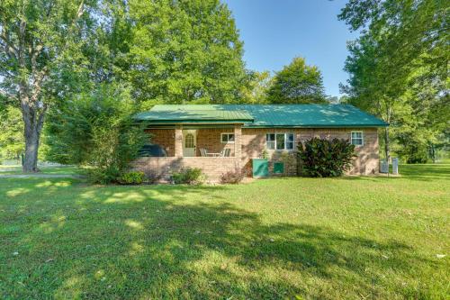 a brick house with a green roof on a yard at Riverfront Home with Porches and Views in Cotter! in Cotter