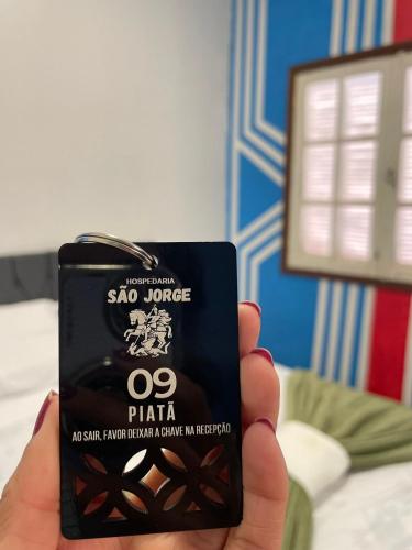 a person holding up a cell phone in their hand at Hospedaria São Jorge in Sao Jorge
