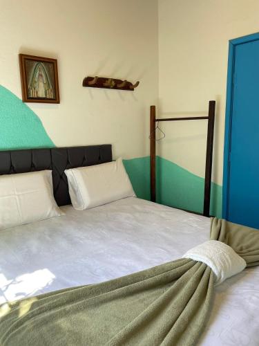 a bedroom with a large white bed with a blue door at Hospedaria São Jorge in Sao Jorge