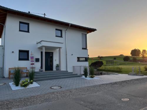 a white house with the sunset in the background at Schönes 1 Zimmer Apartment in Hüfingen