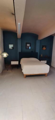 a bedroom with a white bed and blue walls at Casa cuatro in Oaxaca City