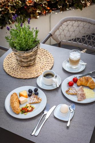 a table with plates of food and a cup of coffee at Aparthotel Jägerheim in Flachau