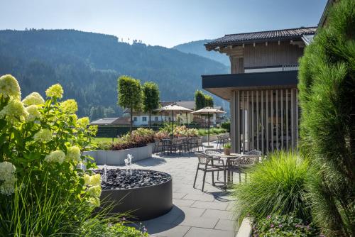 a patio with tables and chairs and plants at Aparthotel Jägerheim in Flachau