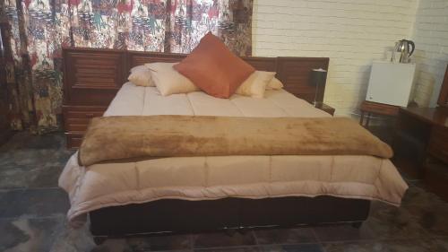 a bedroom with a large bed with pillows on it at Mountain Guesthouse in Pretoria