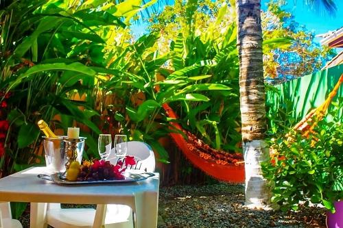 a table with a plate of food on it next to a palm tree at Villa Baobá Pousada & Spa in Búzios