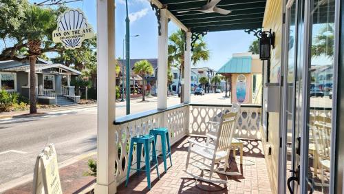 a porch with chairs and a sign on a street at Inn on the Avenue in New Smyrna Beach